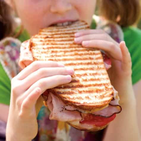 Child eating a ham sandwhich
