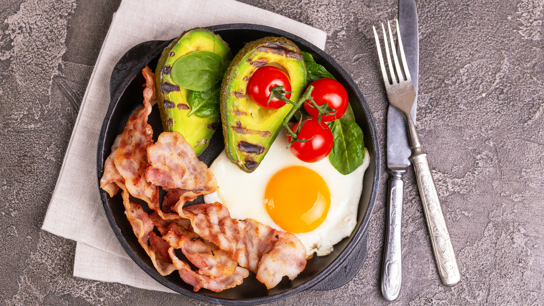 Picture of a high-fat meal containing avocado, bacon, an egg, and tomatoes
