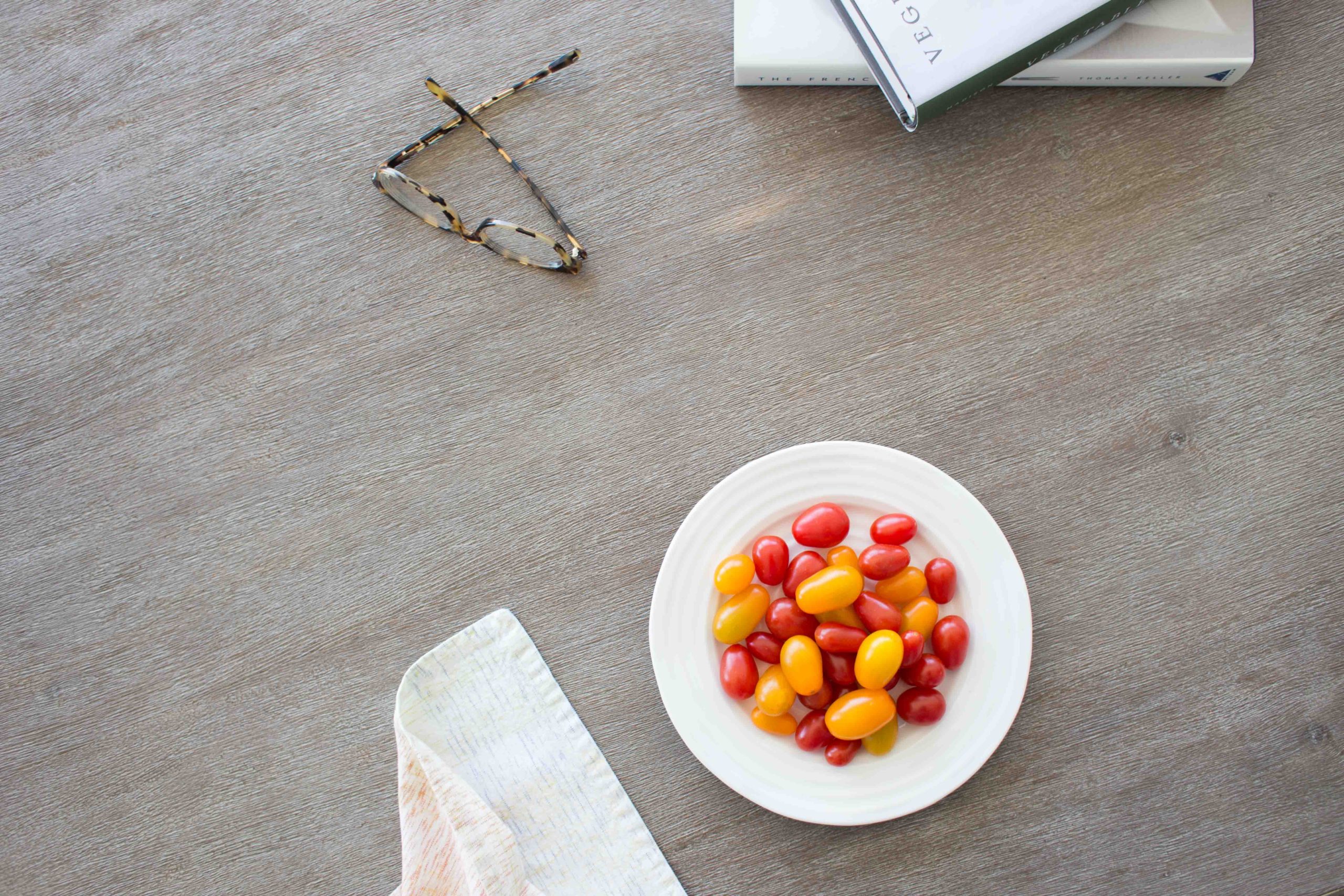 Overhead of table top with glasses and plate of mini tomatoes