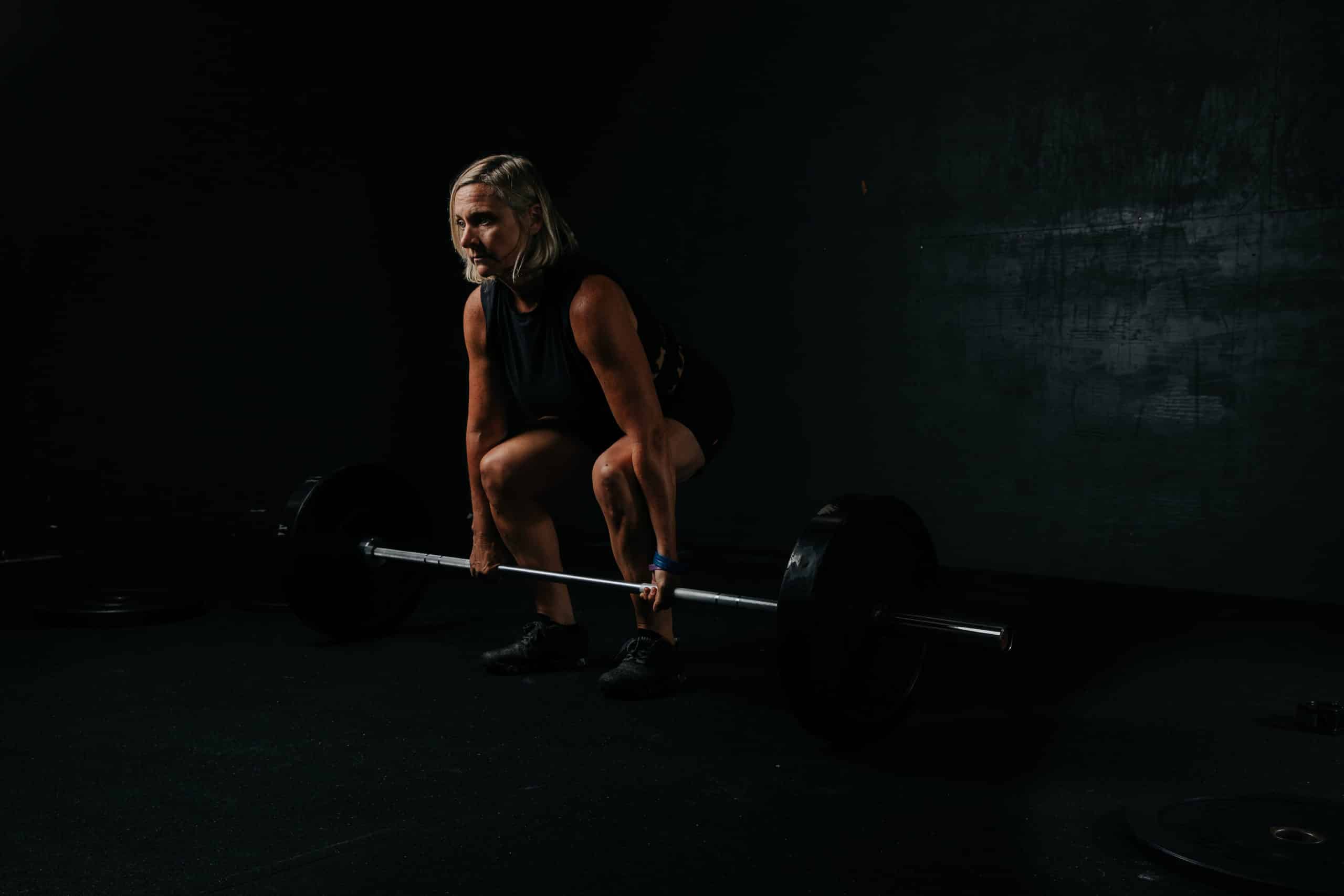 Woman Weight Training in Dark Room