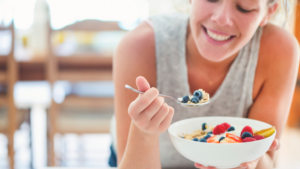 Woman eating fruit and oatmeal