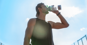 Man drinking from a water bottle outside